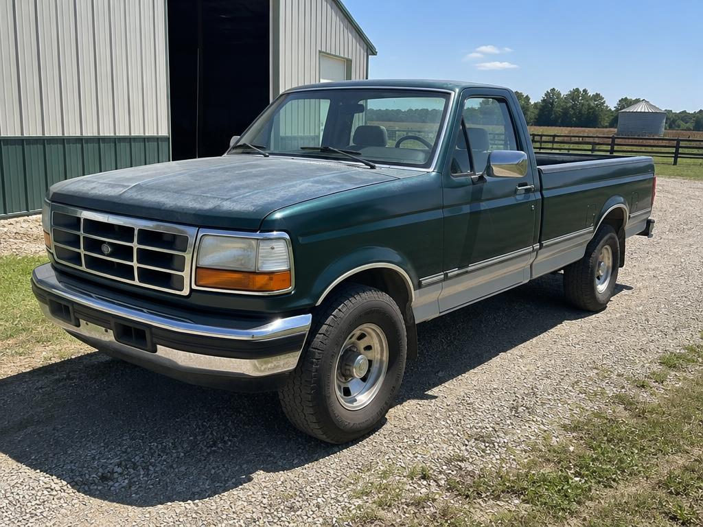 Green and silver 1990s Ford F-150 on a farm driveway