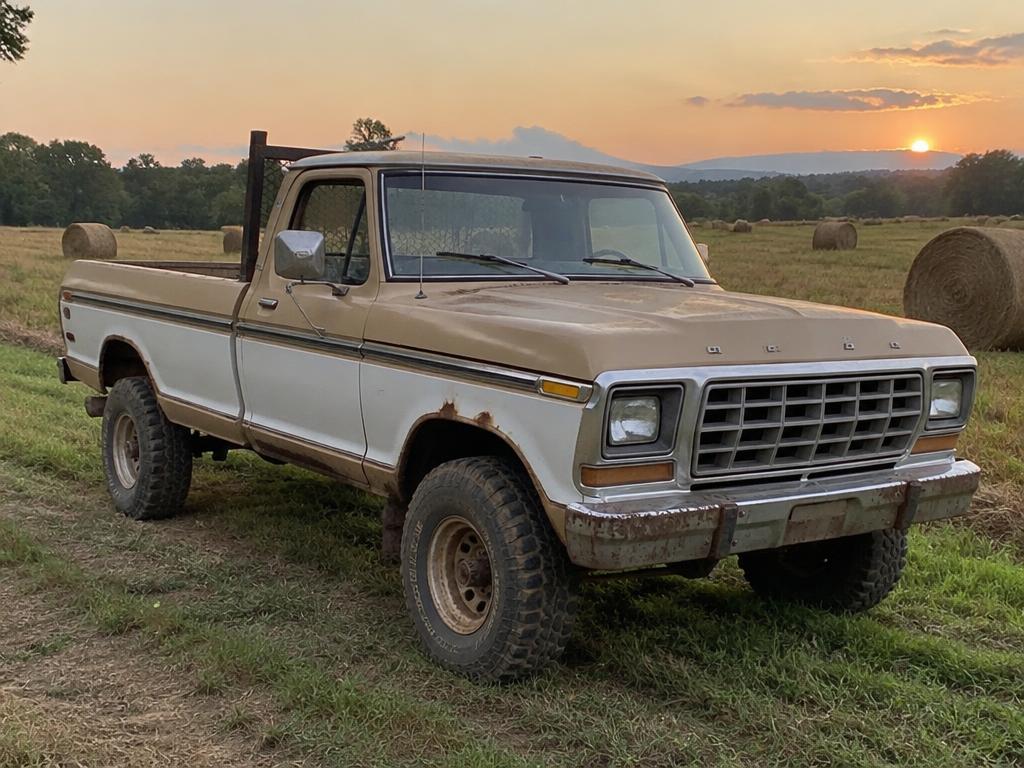 Weathered tan F-250 4x4 work truck in a hay field