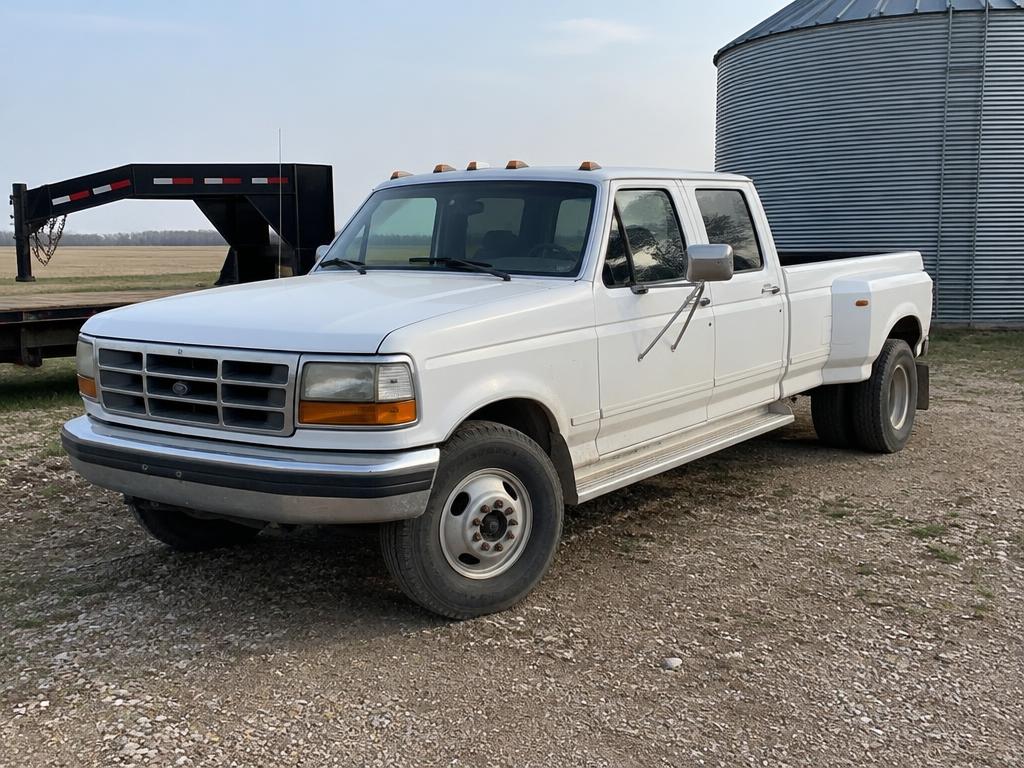White F-350 crew cab dually with a flatbed trailer